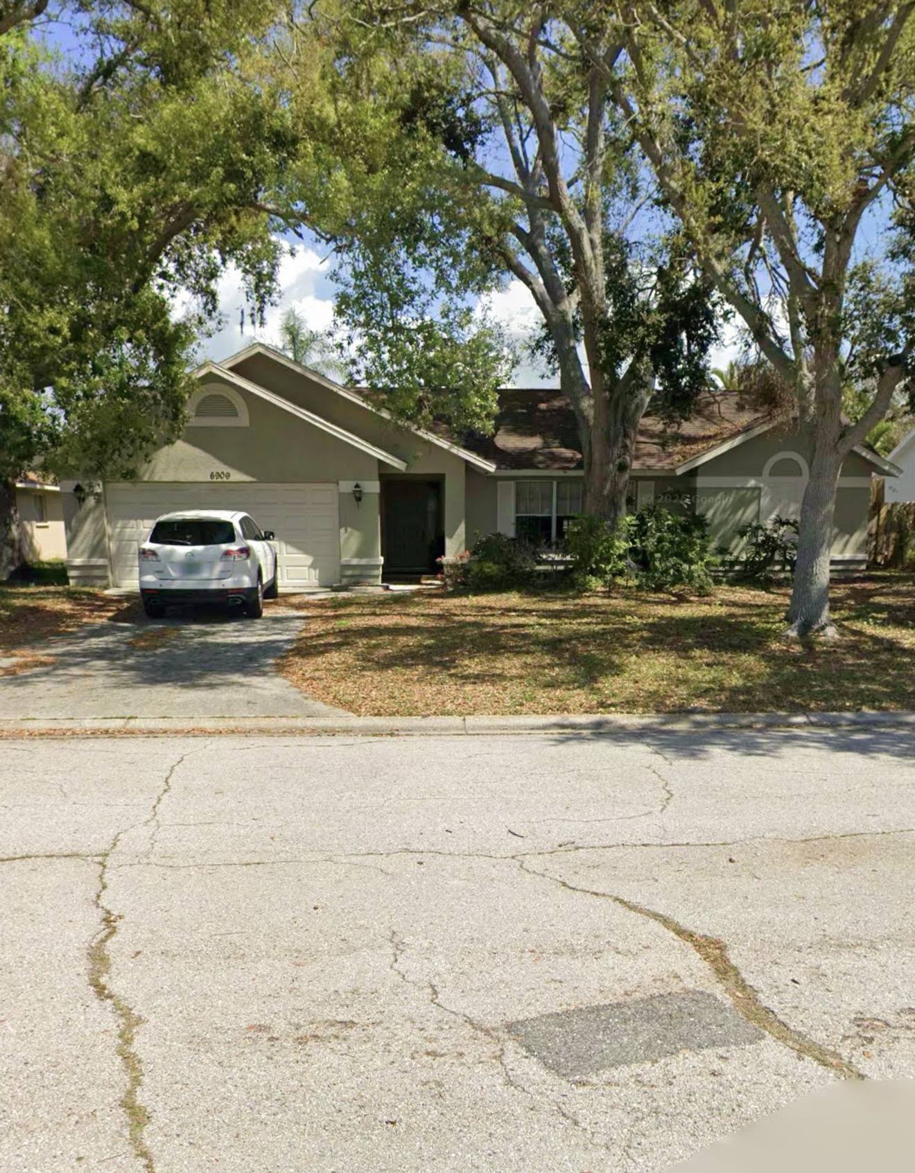 Home purchased by The Melman Group under mature oaks