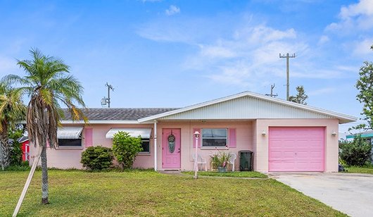 The home before renovation, painted pink with dated finishes